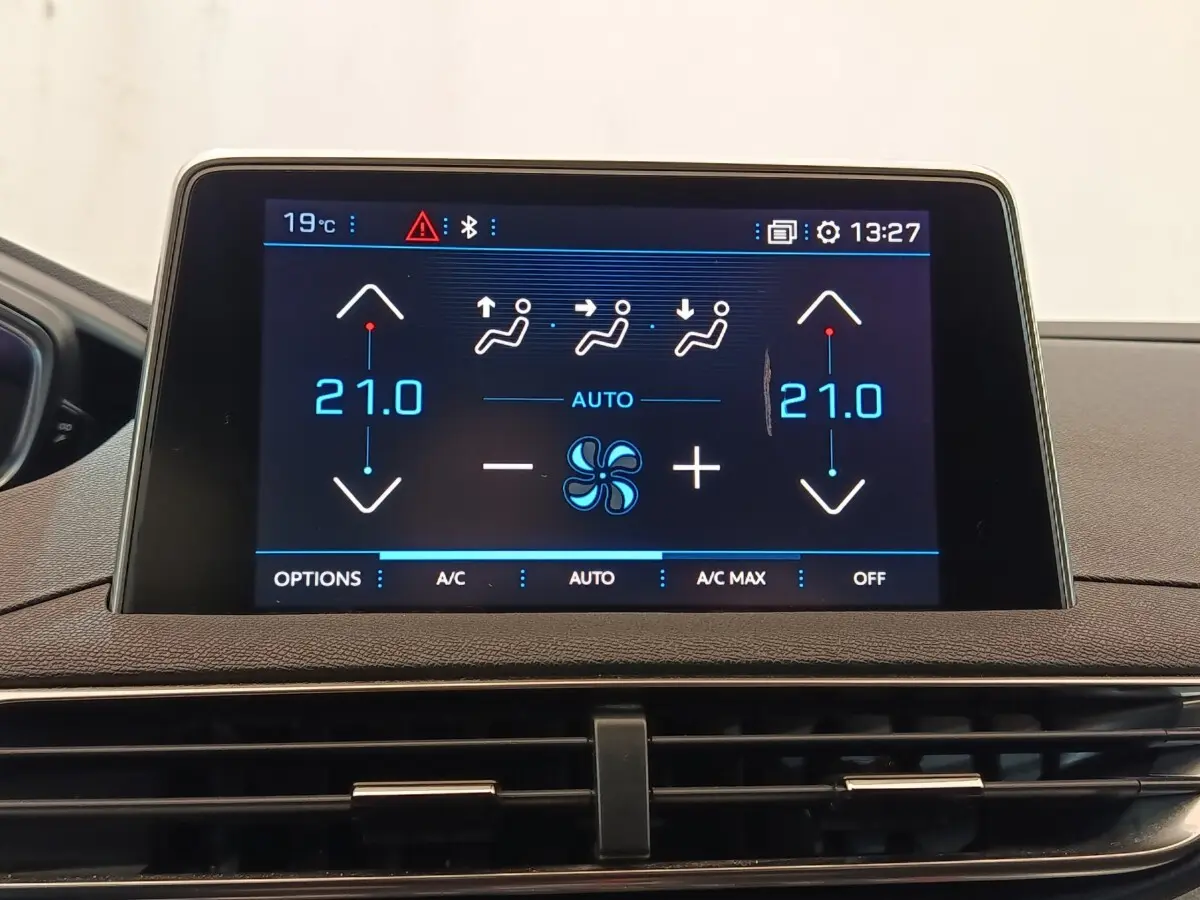 Écran tactile central affichant la climatisation digitale du Peugeot 5008 GT, intérieur noir et tableau de bord gris.