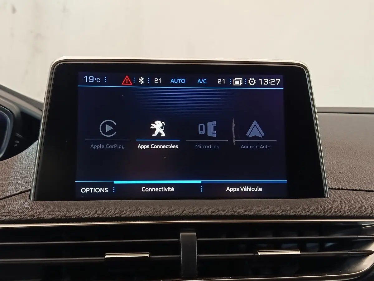 Écran tactile central du tableau de bord du Peugeot 5008 gris clair, affichant les options de connectivité.