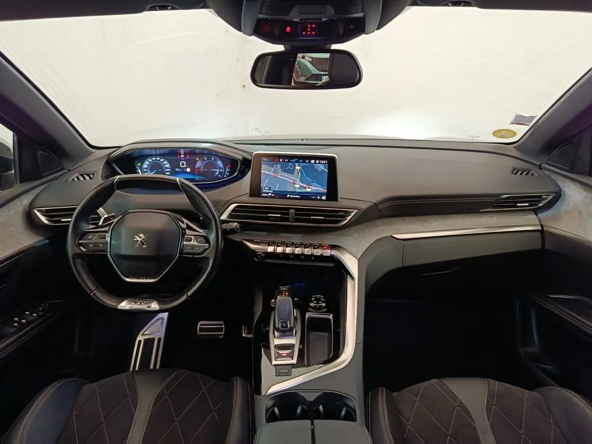 Vue intérieure avant du Peugeot 5008 GT 2019, tableau de bord noir avec écran tactile central et volant compact cuir.