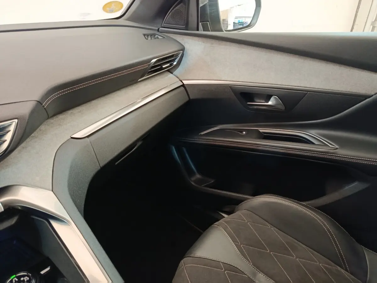 Vue intérieure côté passager du Peugeot 5008 GT 2019, avec tableau de bord gris clair et sellerie cuir noire.