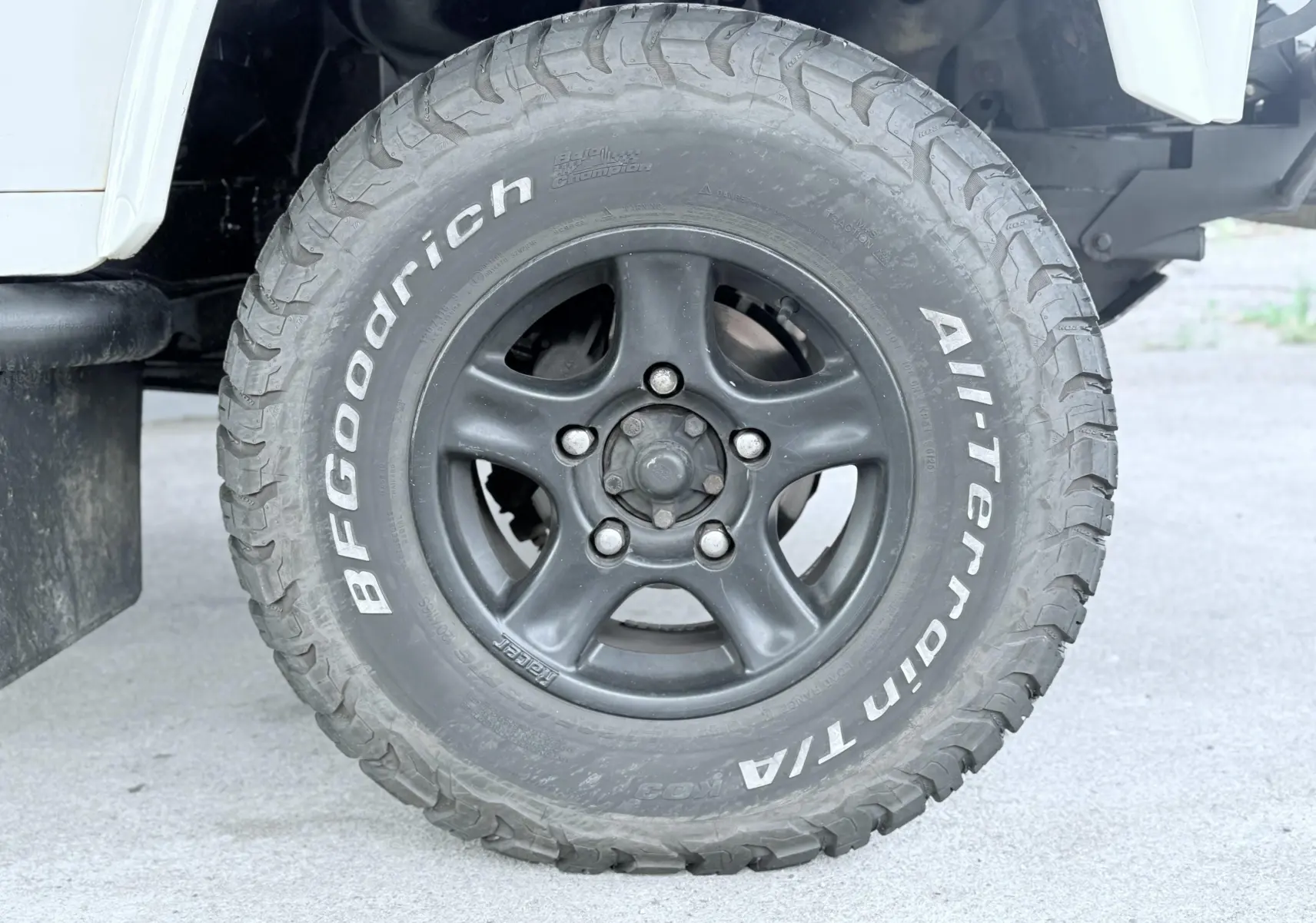 Gros plan sur la roue avant droite du Land Rover Defender blanc de 2007 avec pneu BFGoodrich All-Terrain.