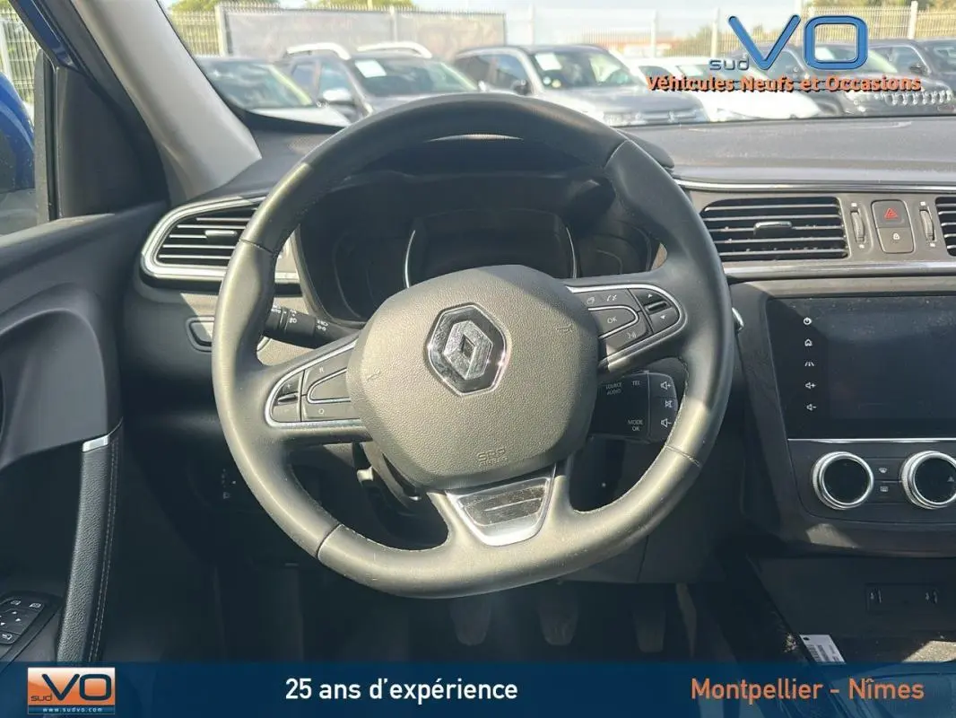Vue intérieure centrée sur le volant de la Renault Kadjar TCe 140 Business, avec tableau de bord et écran tactile visibles.
