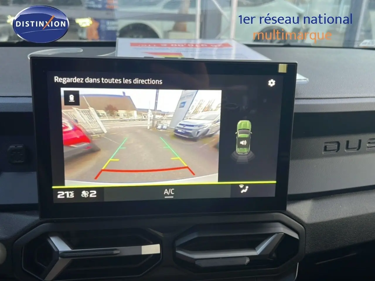 Écran central montrant la caméra de recul du Dacia Duster 1.6 Hybrid blanc glacier, tableau de bord noir avec logo Duster.