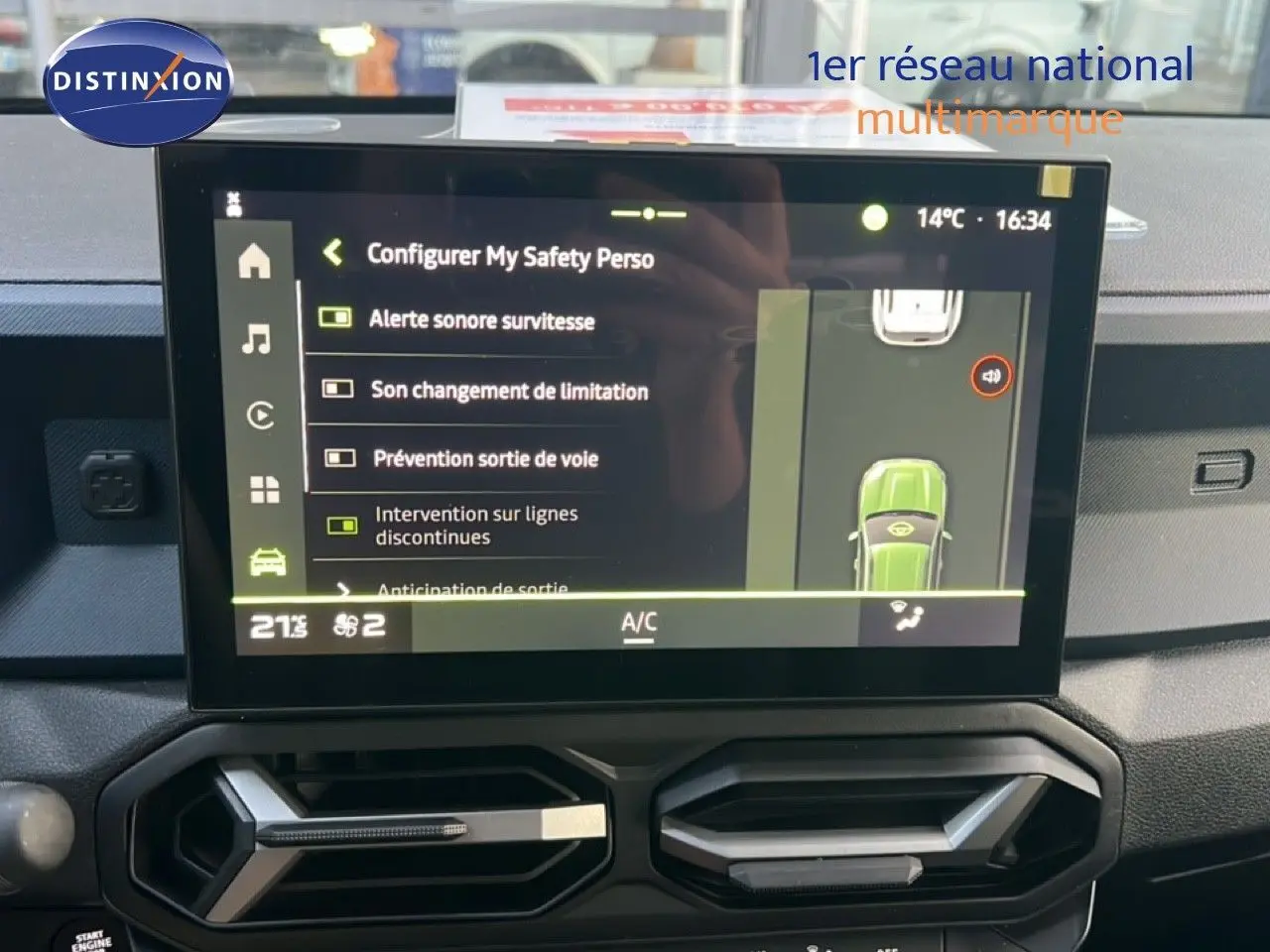 Écran tactile central du Dacia Duster blanc glacier 2025 montrant les options d’aide à la conduite et la climatisation.