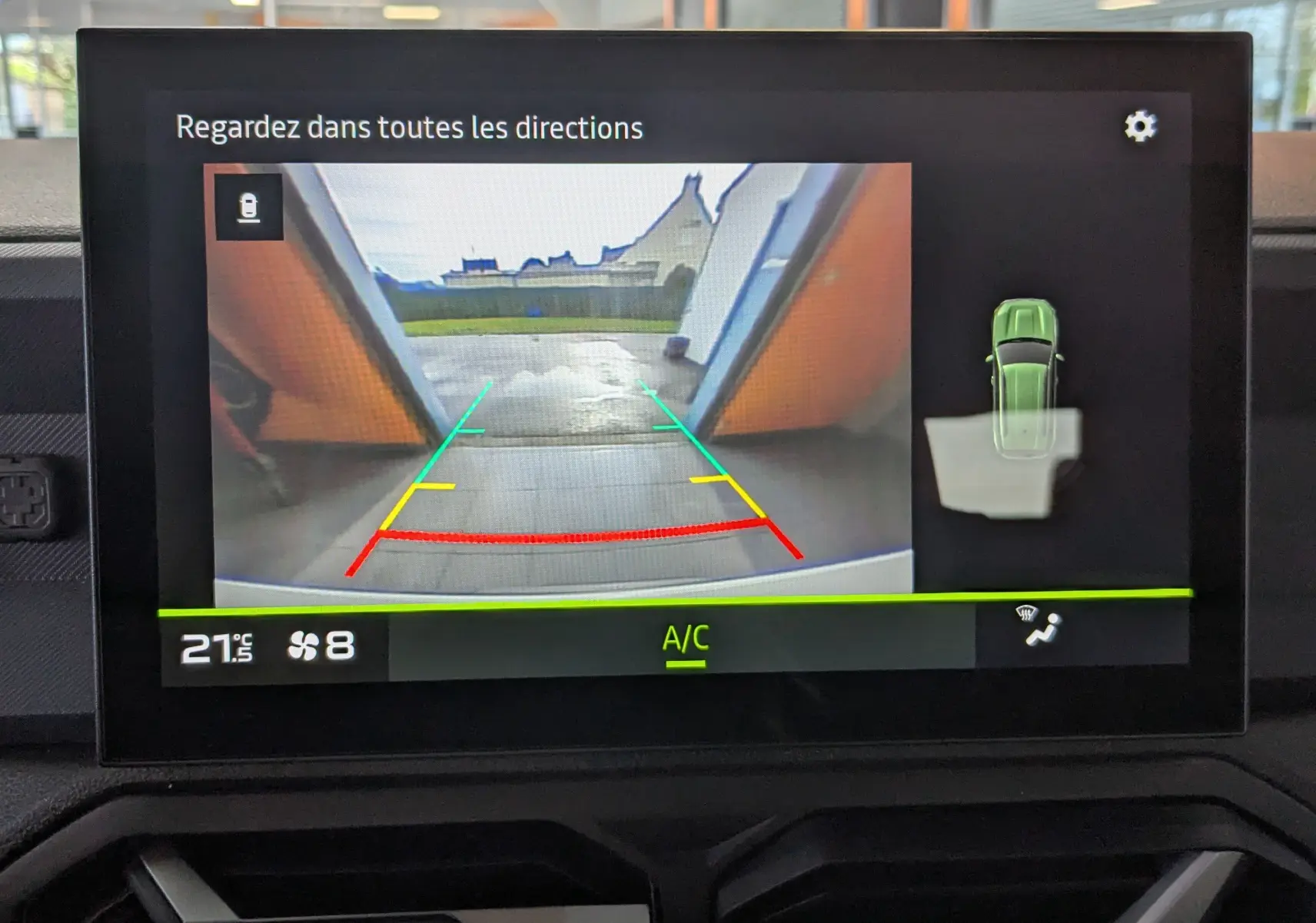 Écran central du Dacia Duster 2025 montrant la caméra de recul avec guidage coloré et vue 360° du véhicule blanc glacier.