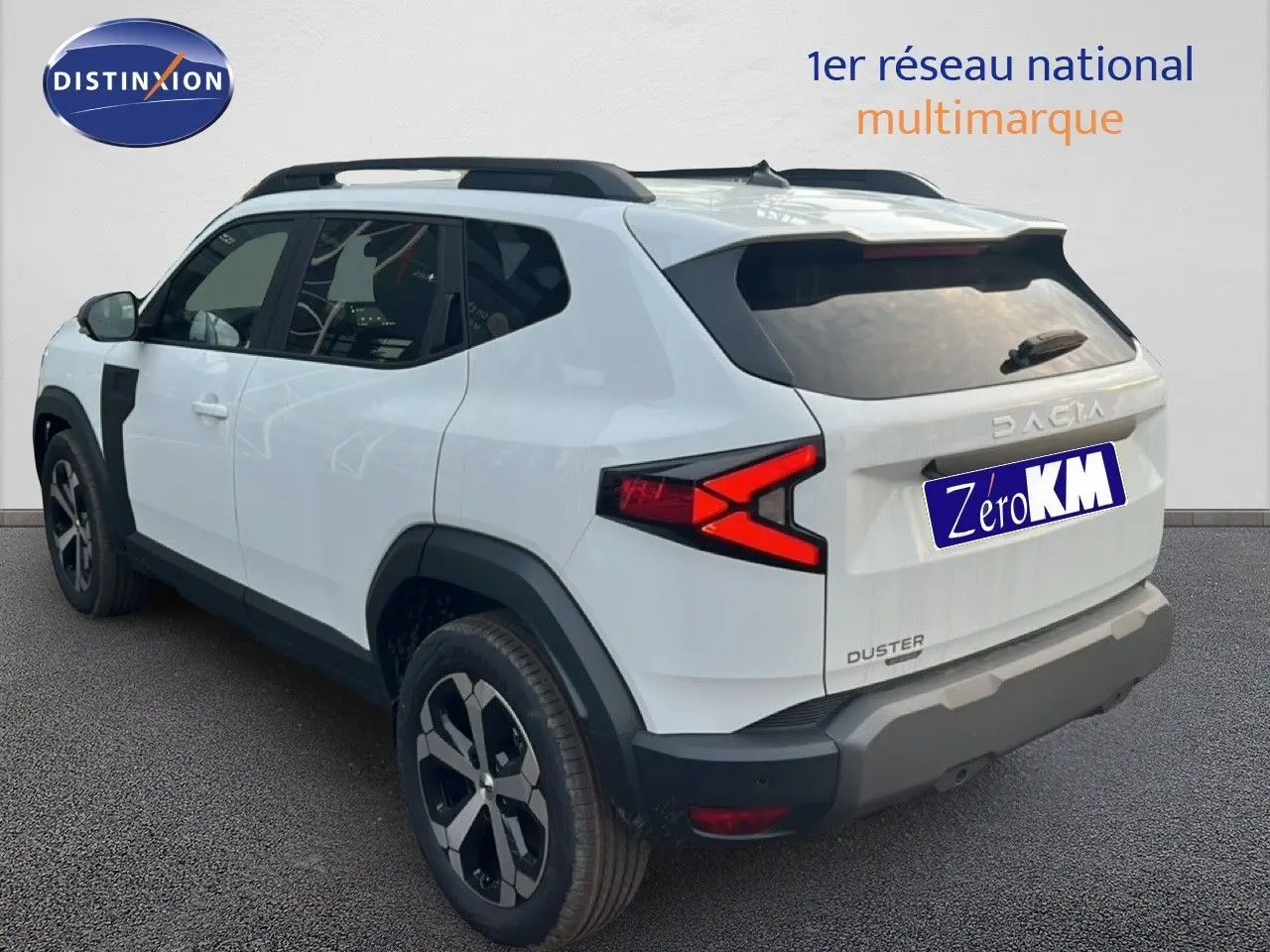 Vue 3/4 arrière droite du Dacia Duster blanc glacier 2025 avec jantes biton et feux arrière distinctifs en X.
