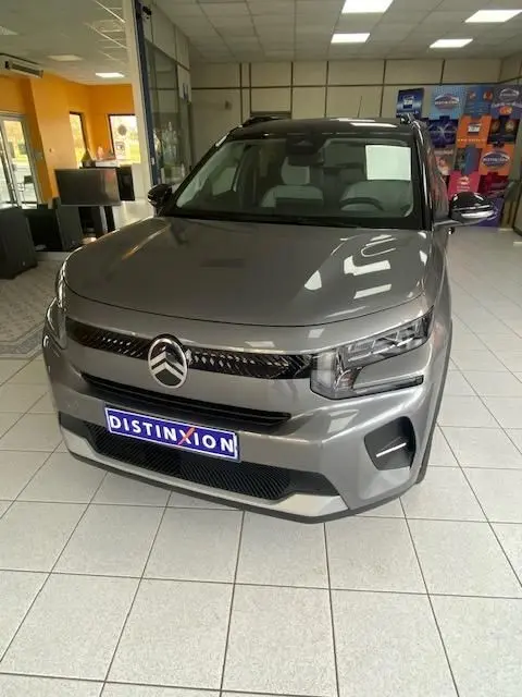 Citroën C3 turbo 100cv gris Mercury vue 3/4 avant en intérieur, avec calandre noire et phares LED distinctifs.