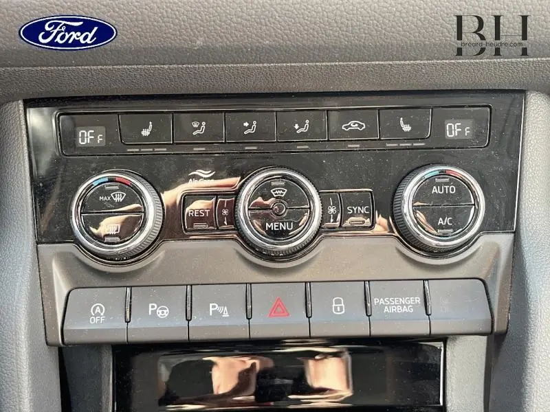 Panneau de commandes de climatisation et aides à la conduite d'un Skoda Kodiaq bleu, vue frontale rapprochée.