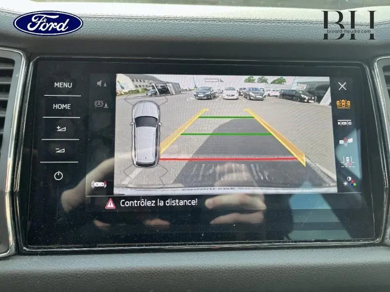 Écran de caméra de recul affichant une vue arrière avec repères colorés, dans un Skoda Kodiaq Bleu Lave métallisé.
