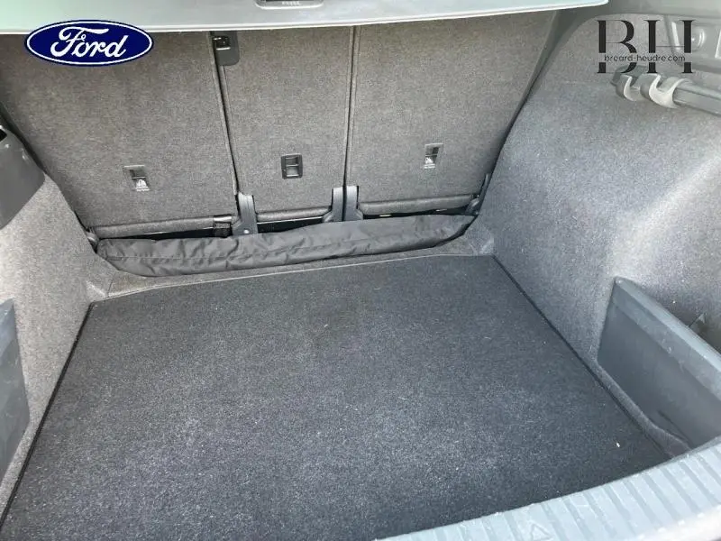 Coffre vu de l'arrière, intérieur spacieux et tapis noir, sans objet visible, sans indication spécifique du modèle.