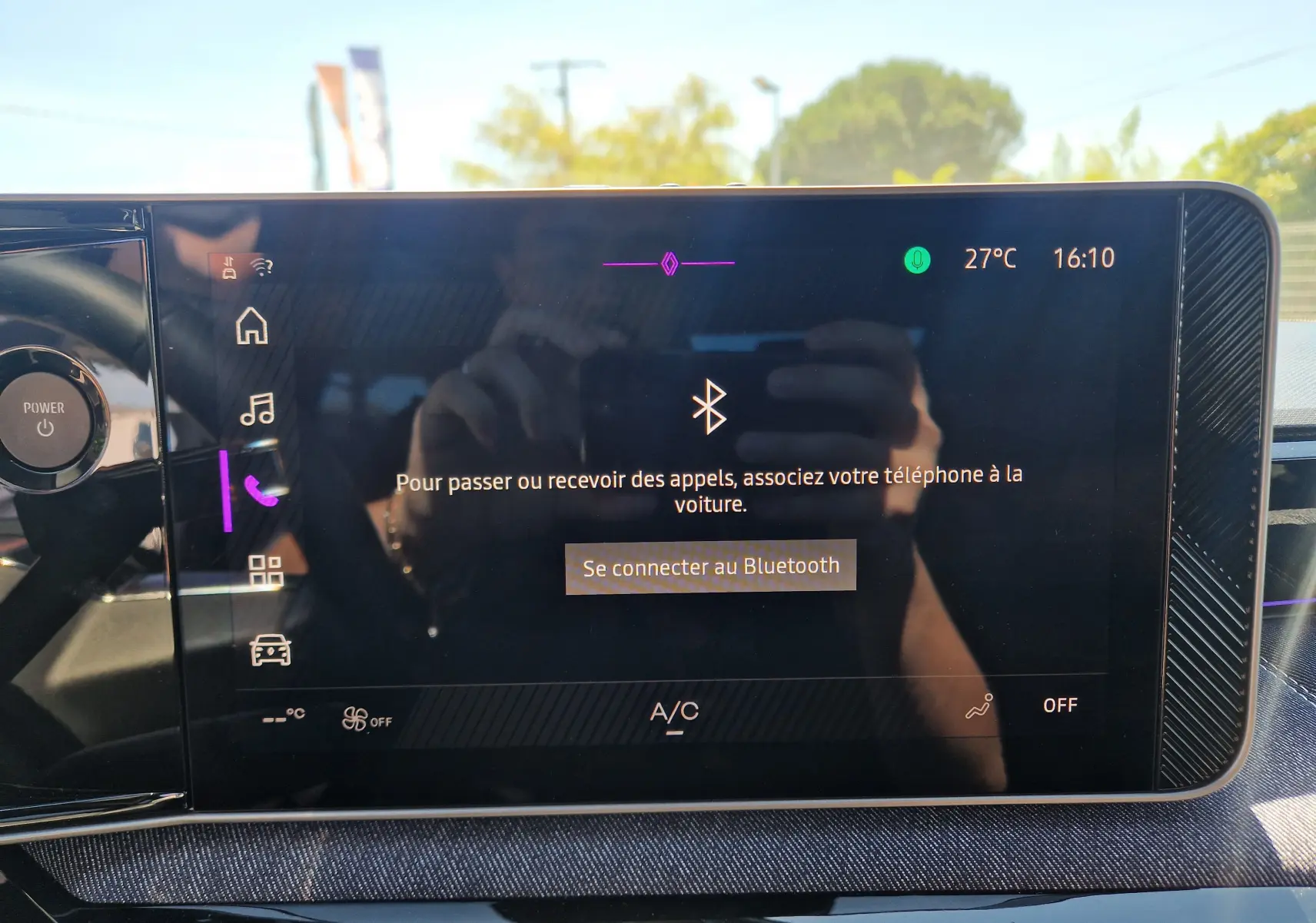 Écran tactile central du Renault R5 E-TECH 2025 affichant la connexion Bluetooth avec reflet extérieur lumineux.