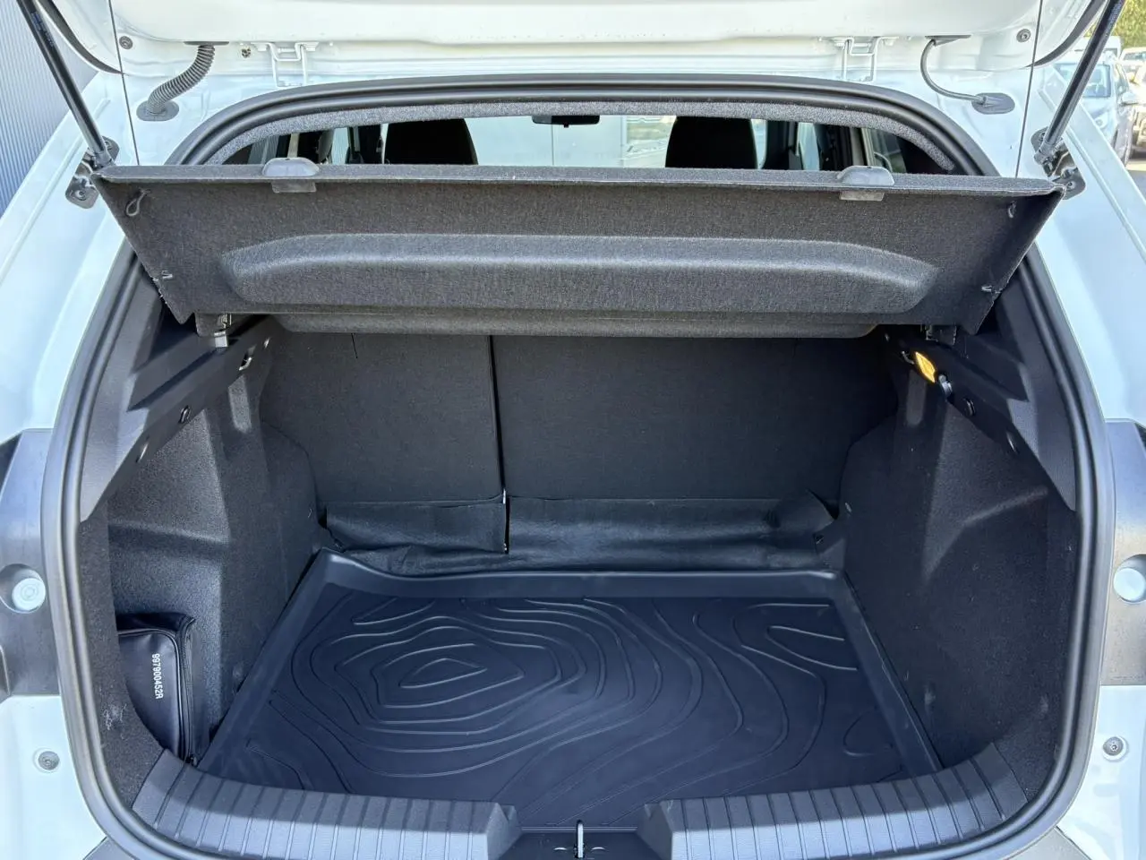 Coffre ouvert du Dacia Duster Blanc Glacier 2026, vue arrière montrant l’espace de chargement et la housse de protection noire.