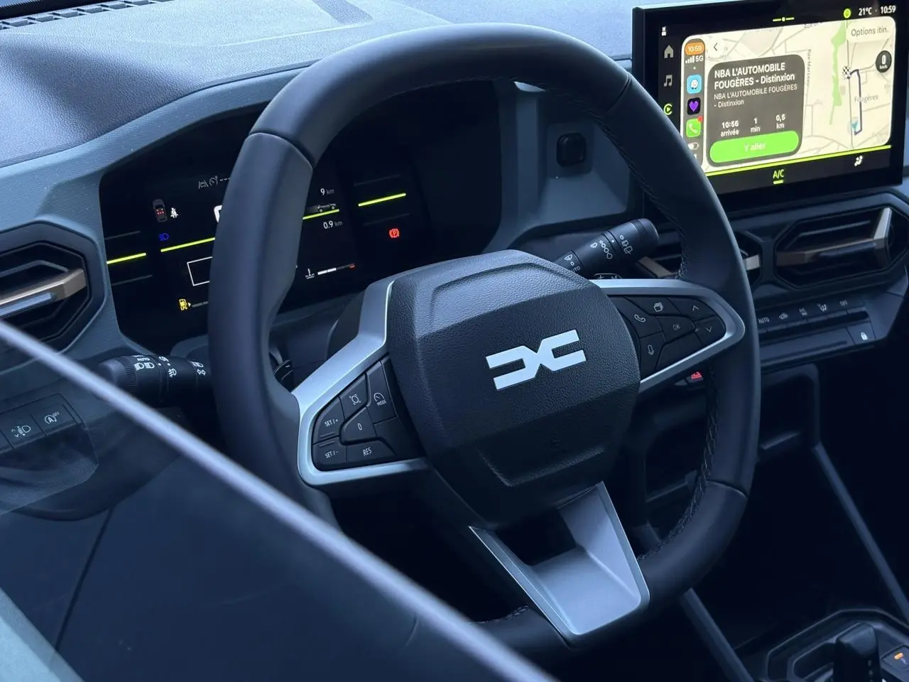 Vue intérieure rapprochée du volant et tableau de bord digital du Dacia Duster 2026 avec écran tactile central.