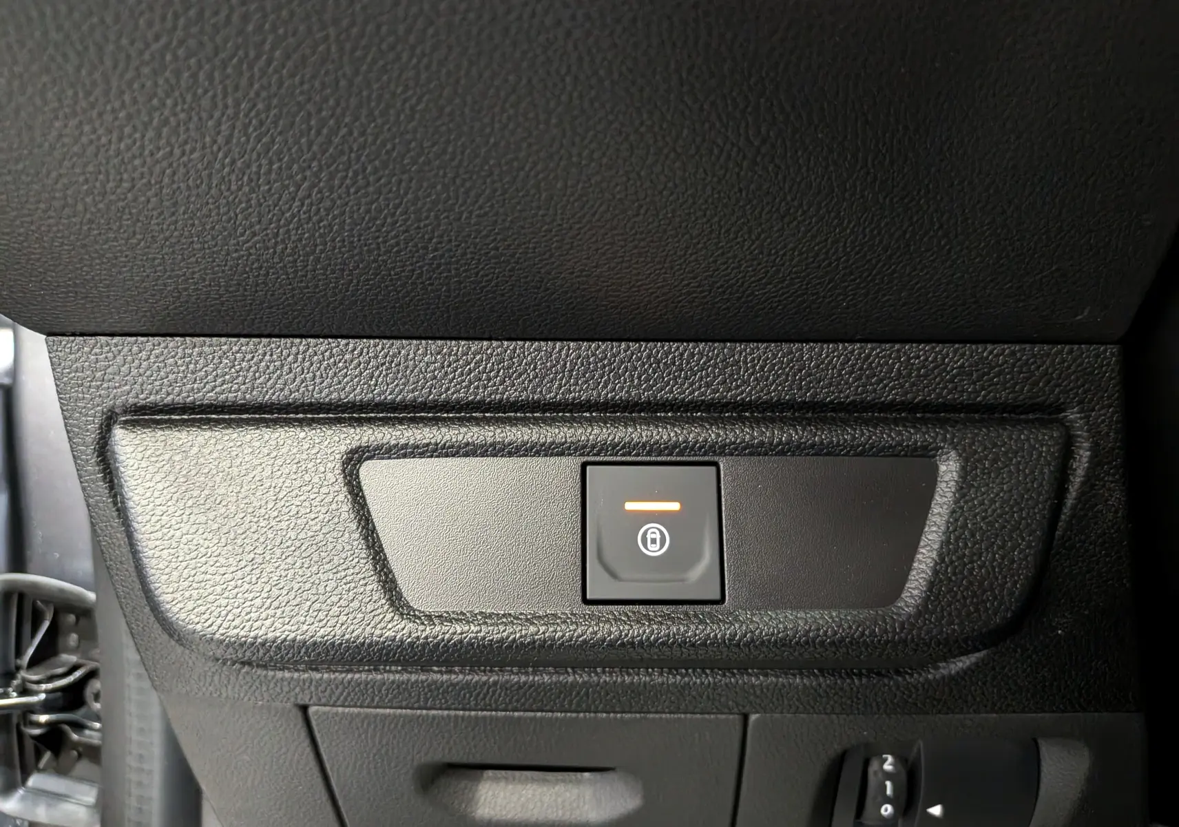 Gros plan sur le bouton de verrouillage centralisé orange dans l’habitacle noir du Dacia Sandero Stepway 2025.