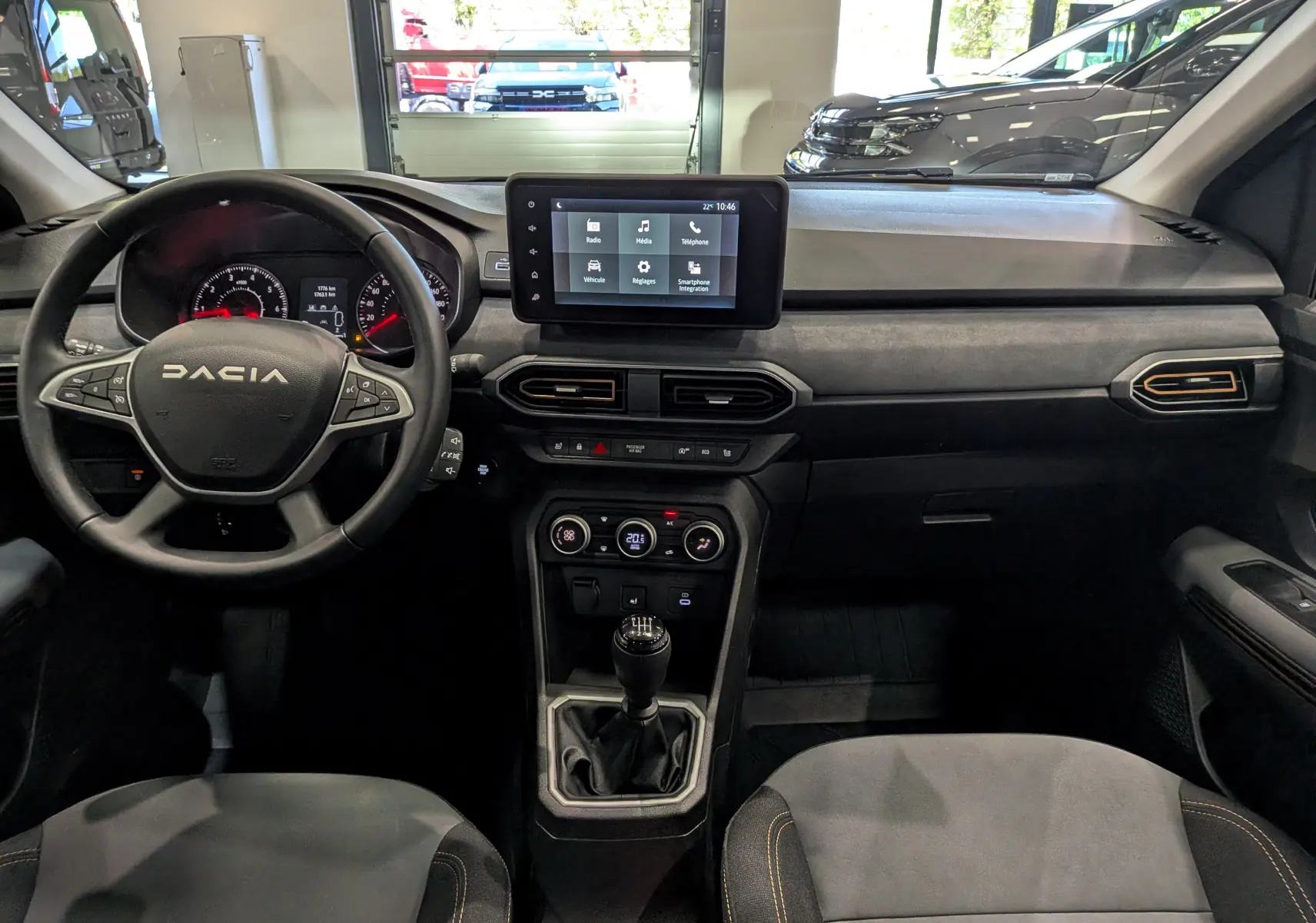 Vue intérieure frontale du tableau de bord et volant noir de la Dacia Sandero Stepway TCe 110 Gris Schiste avec écran tactile et boîte manuelle.