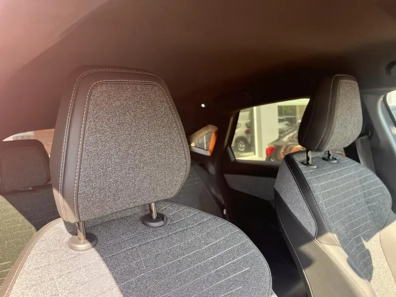 Vue intérieure sur les sièges avant en tissu gris Crispy avec surpiqûres, dans un Peugeot 3008 hybride 2025.