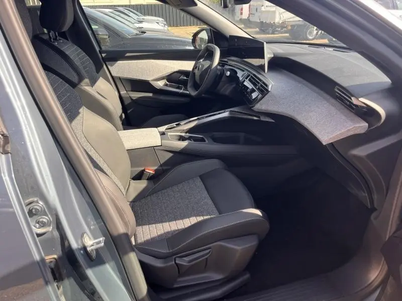 Vue intérieure côté conducteur du Peugeot 3008 gris Artense, avec sièges tissu CRISPY/TEP et tableau de bord moderne.