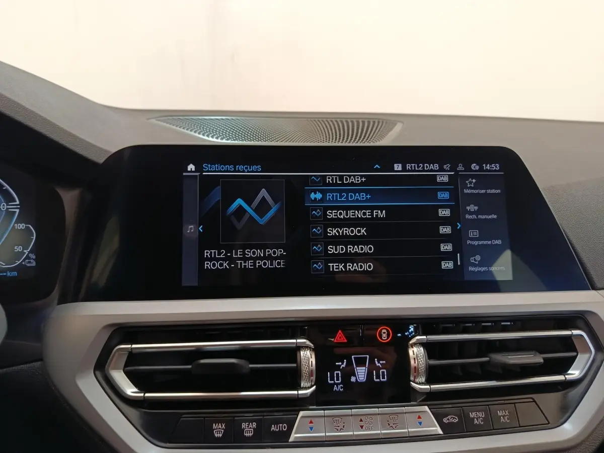 Vue rapprochée de l’écran tactile central et des commandes de climatisation d’une BMW Série 3 320e hybride rechargeable.