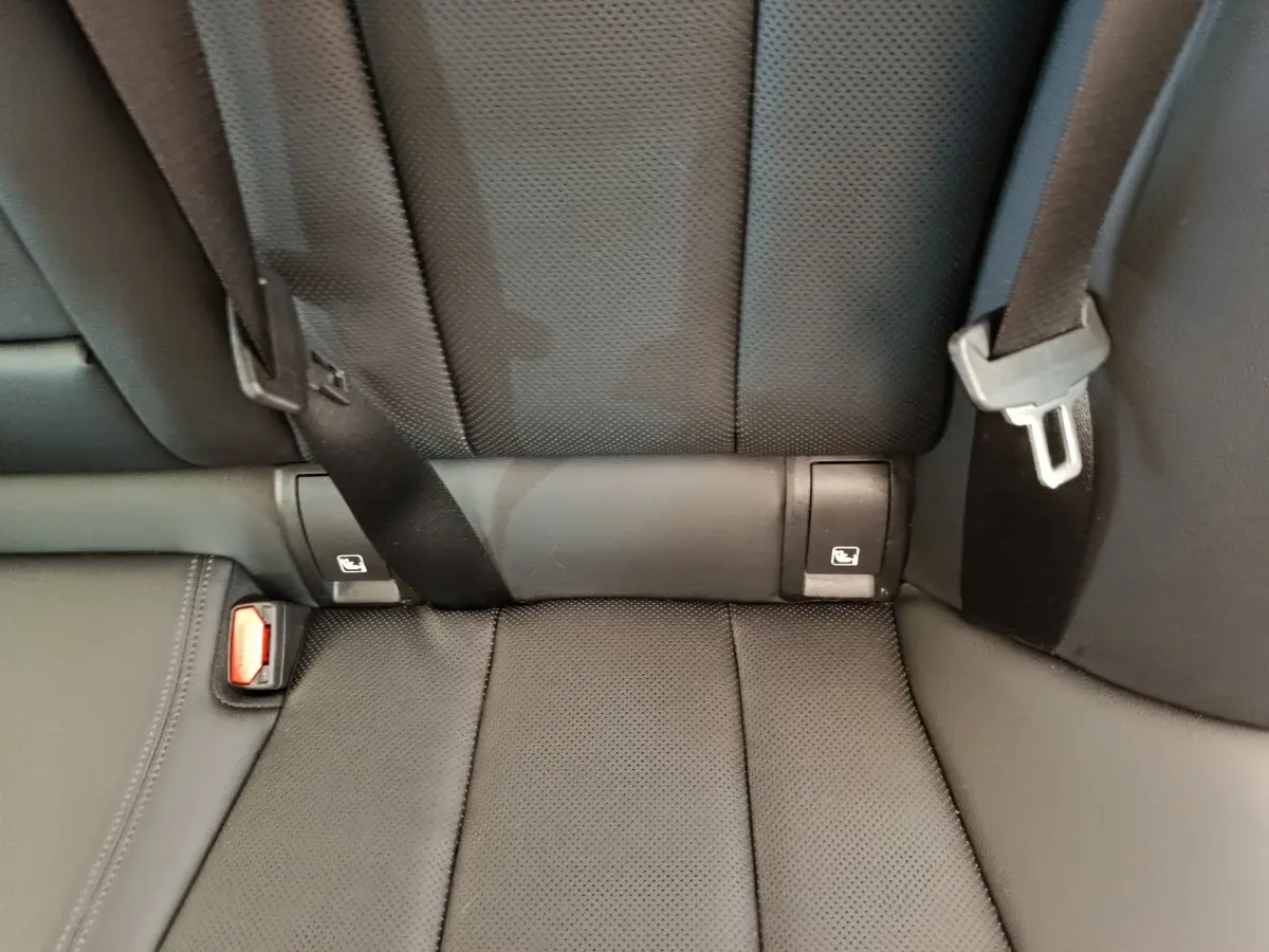 Gros plan sur la banquette arrière noire perforée avec ceintures et fixations Isofix visibles dans une BMW Série 3 320e hybride.