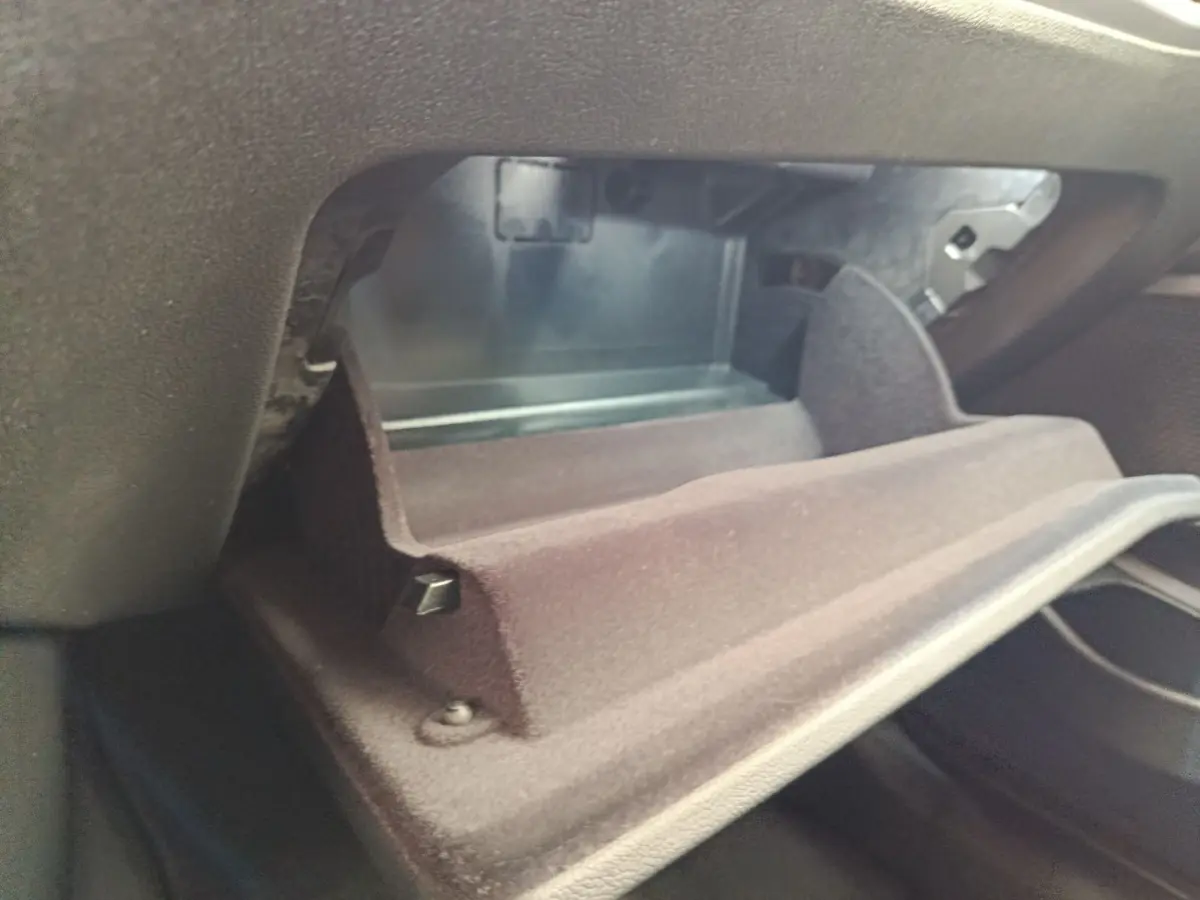 Vue rapprochée de la boîte à gants ouverte de la BMW Série 3 320e blanche, intérieur noir.