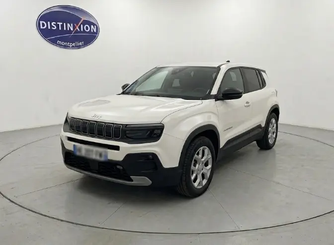 Jeep Avenger blanc en 3/4 avant droit, avec calandre noire distinctive et éléments de protection noirs sur les bas de caisse.