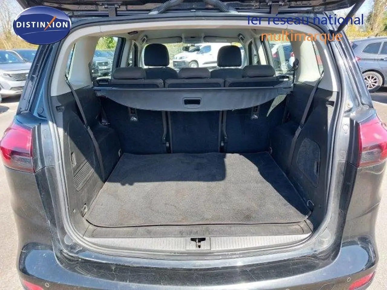 Coffre ouvert en vue arrière d’une Opel Zafira noire métal 2017, montrant l’espace de chargement et la banquette arrière.