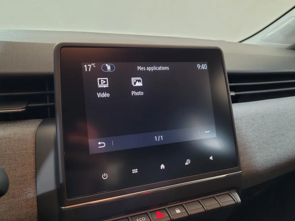 Écran tactile central affichant les applications vidéo et photo dans l'habitacle de la Renault Clio bleu Evolution 2025.