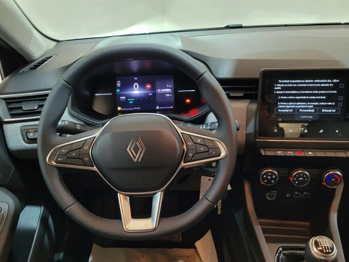 Vue intérieure centrée sur le volant cuir de la Renault Clio 2025 avec tableau de bord digital et écran tactile.