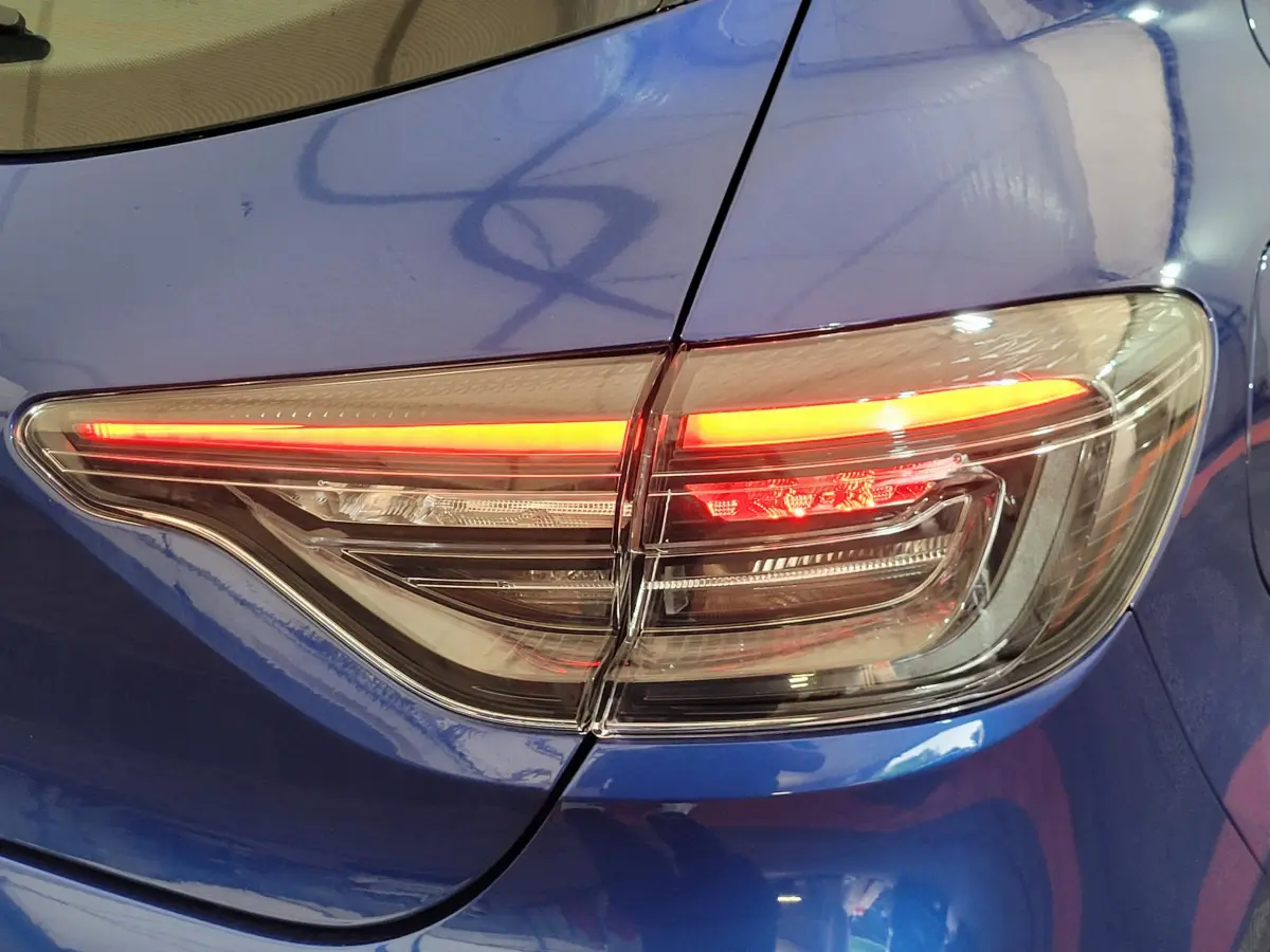 Feu arrière droit allumé sur Renault Clio Evolution Blue dCi 100 bleu, vue rapprochée du coffre et aile arrière.