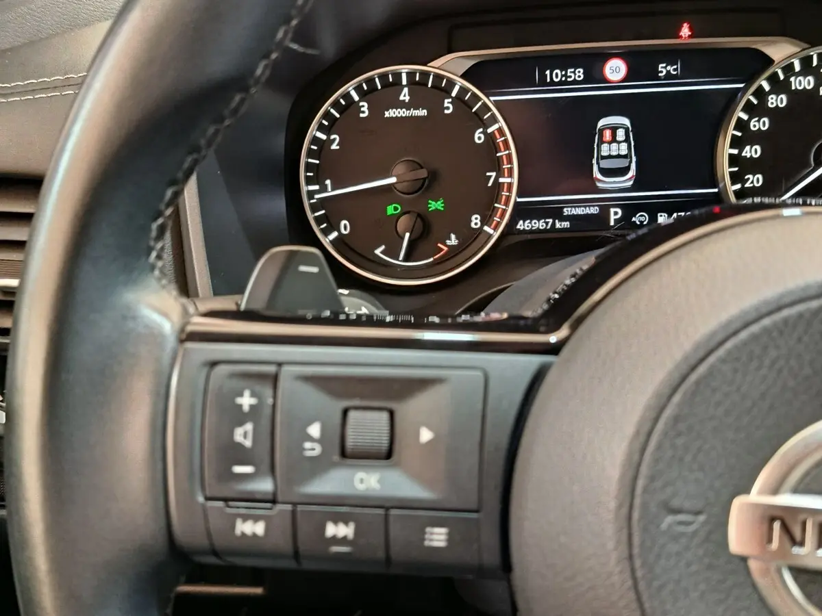 Gros plan sur le combiné d'instruments et le volant cuir noir du Nissan Qashqai 2022, affichage digital et commandes au volant.
