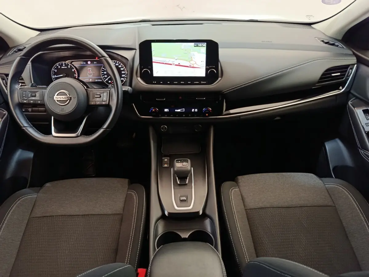 Vue intérieure avant du Nissan Qashqai 1.3 MHEV 2022, tableau de bord avec écran tactile et volant multifonctions noir.