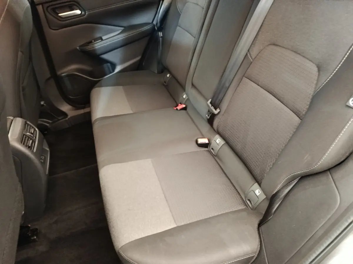 Vue intérieure côté droit de la banquette arrière gris foncé du Nissan Qashqai 1.3 MHEV 2022 avec ceintures visibles.