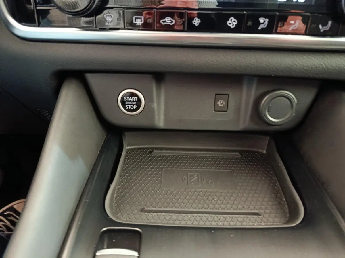 Détail intérieur du Nissan Qashqai 2022 montrant la zone de recharge sans fil et le bouton démarrage/arrêt moteur.