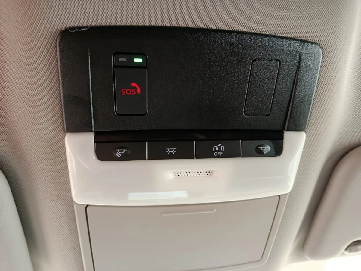 Vue en gros plan du panneau de commande au plafond intérieur du Nissan Qashqai gris foncé, avec bouton SOS et commandes d’éclairage.