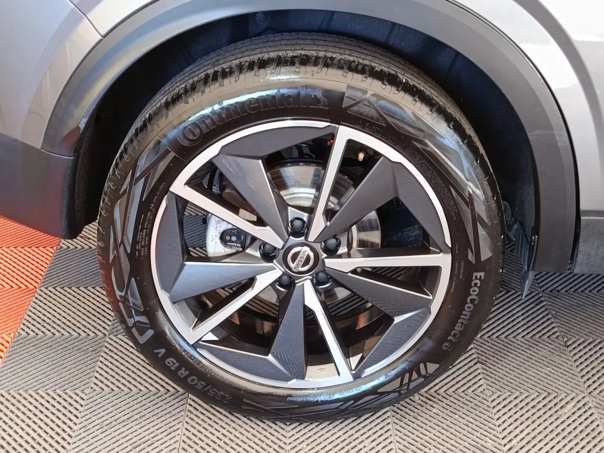 Gros plan sur la roue avant droite gris foncé du Nissan Qashqai 1.3 MHEV 158ch avec jante alliage distinctive.