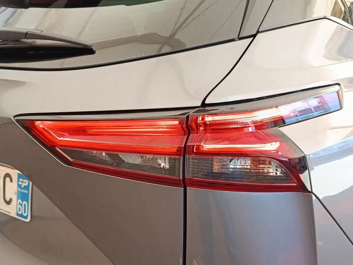 Feu arrière droit rouge et blanc d’un Nissan Qashqai gris foncé, vue rapprochée du coin arrière du véhicule.