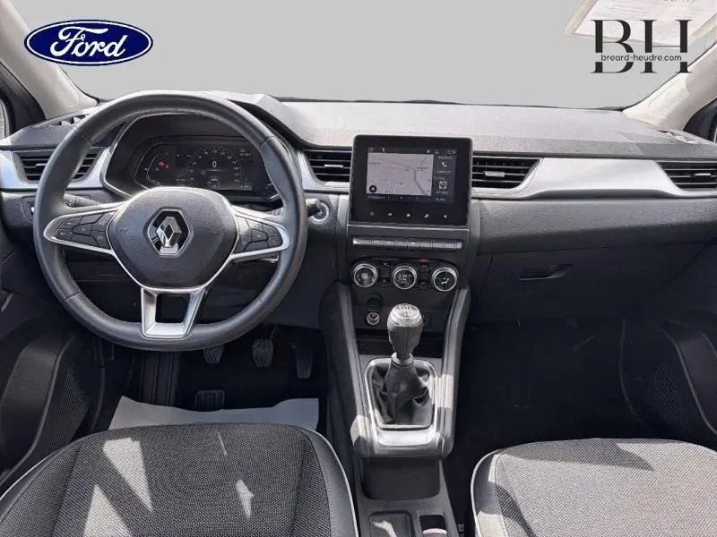 Vue intérieure avant du Renault Captur 1.3 TCe 140ch Intens 2022, tableau de bord noir avec écran tactile et levier de vitesse manuel.