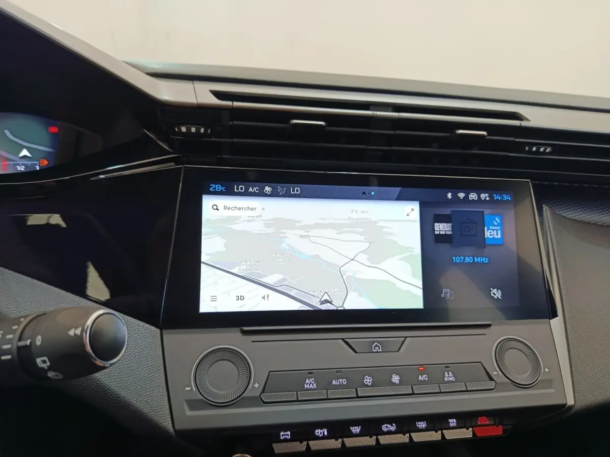 Vue rapprochée du tableau de bord de la Peugeot 308 2024 avec écran tactile central affichant une carte de navigation.