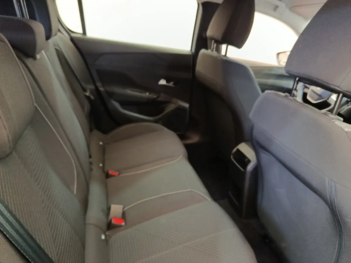 Vue intérieure arrière côté gauche montrant les sièges tissu gris foncé de la Peugeot 308 2024.
