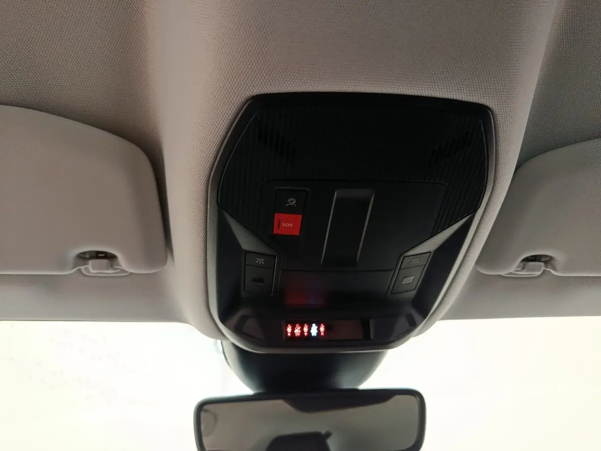 Vue intérieure du plafond avant de la Peugeot 308 blanche 2024, avec bouton SOS et éclairage de sécurité rouge.