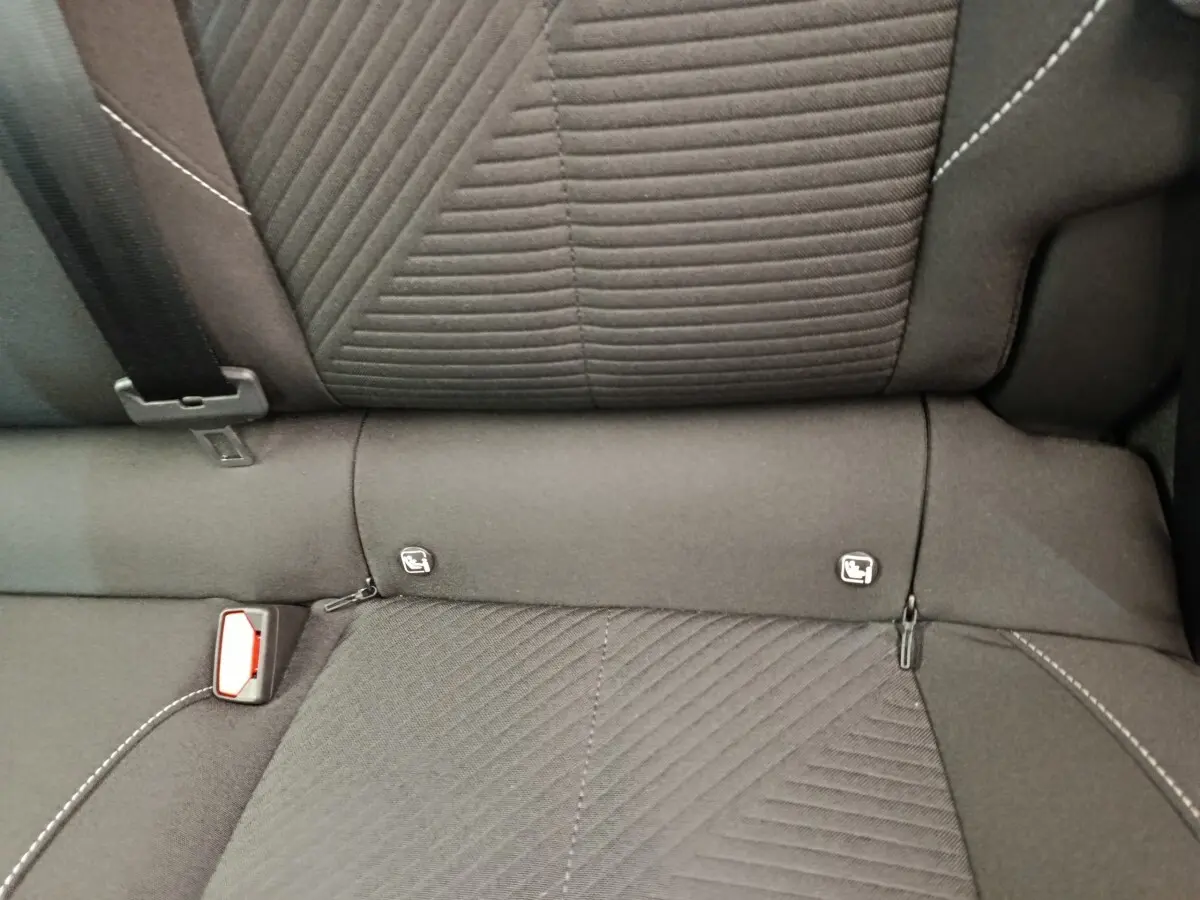 Gros plan sur la banquette arrière noire de la Peugeot 308 2024, montrant les fixations Isofix et la ceinture de sécurité.