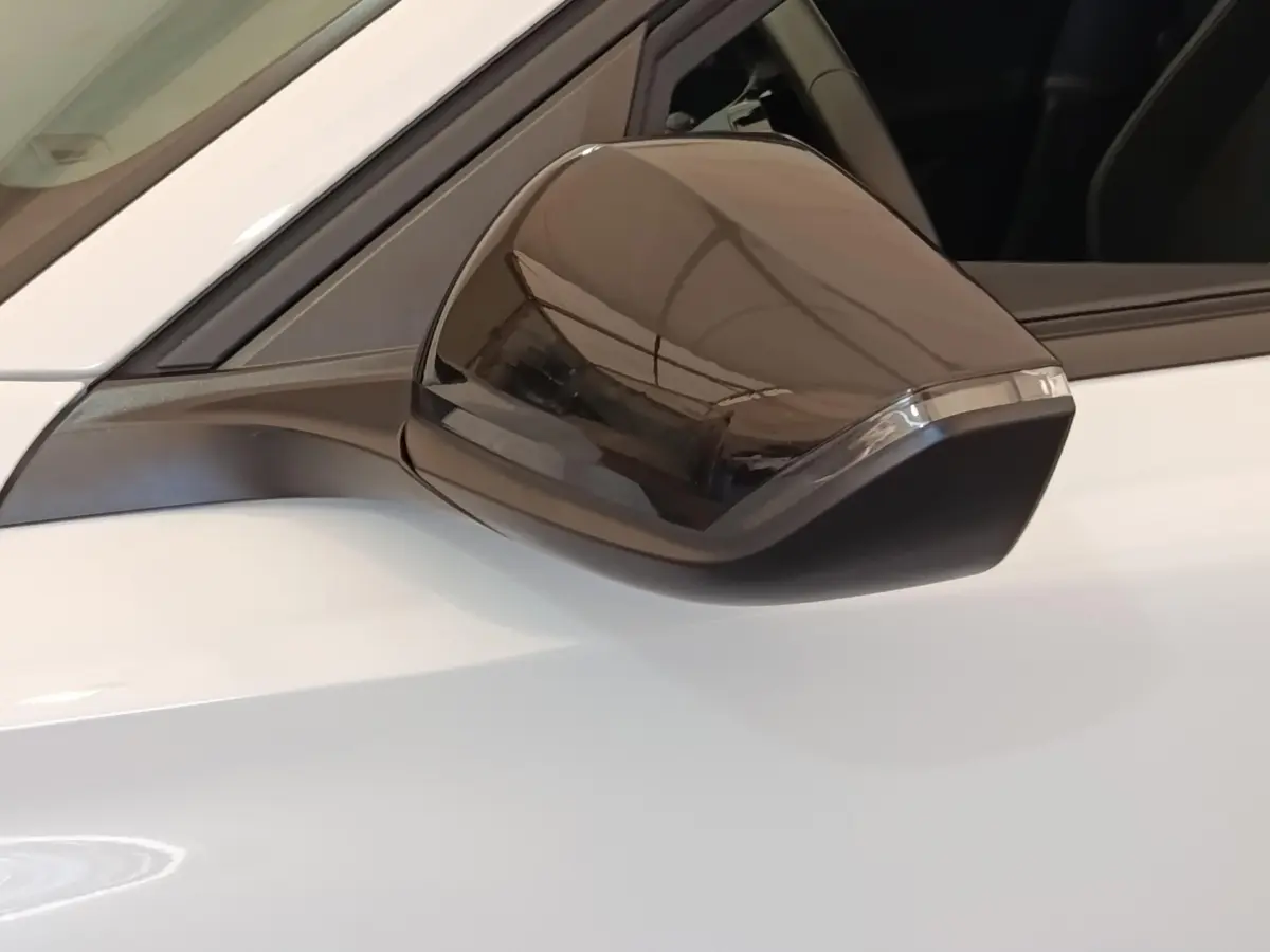 Rétroviseur noir en gros plan côté gauche d'une Peugeot 308 blanche 2024 Active Pack essence.