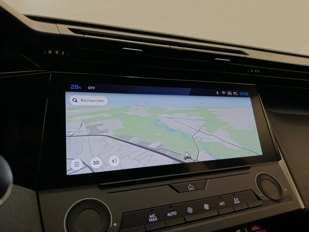 Écran tactile central affichant la navigation dans l’habitacle de la Peugeot 308 blanche, vue de face rapprochée.