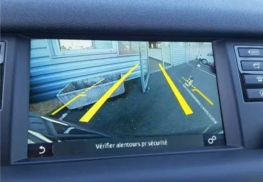 Vue caméra de recul avec guidage jaune du Land Rover Discovery Sport noir, version TD4 150 SE A de 2017.