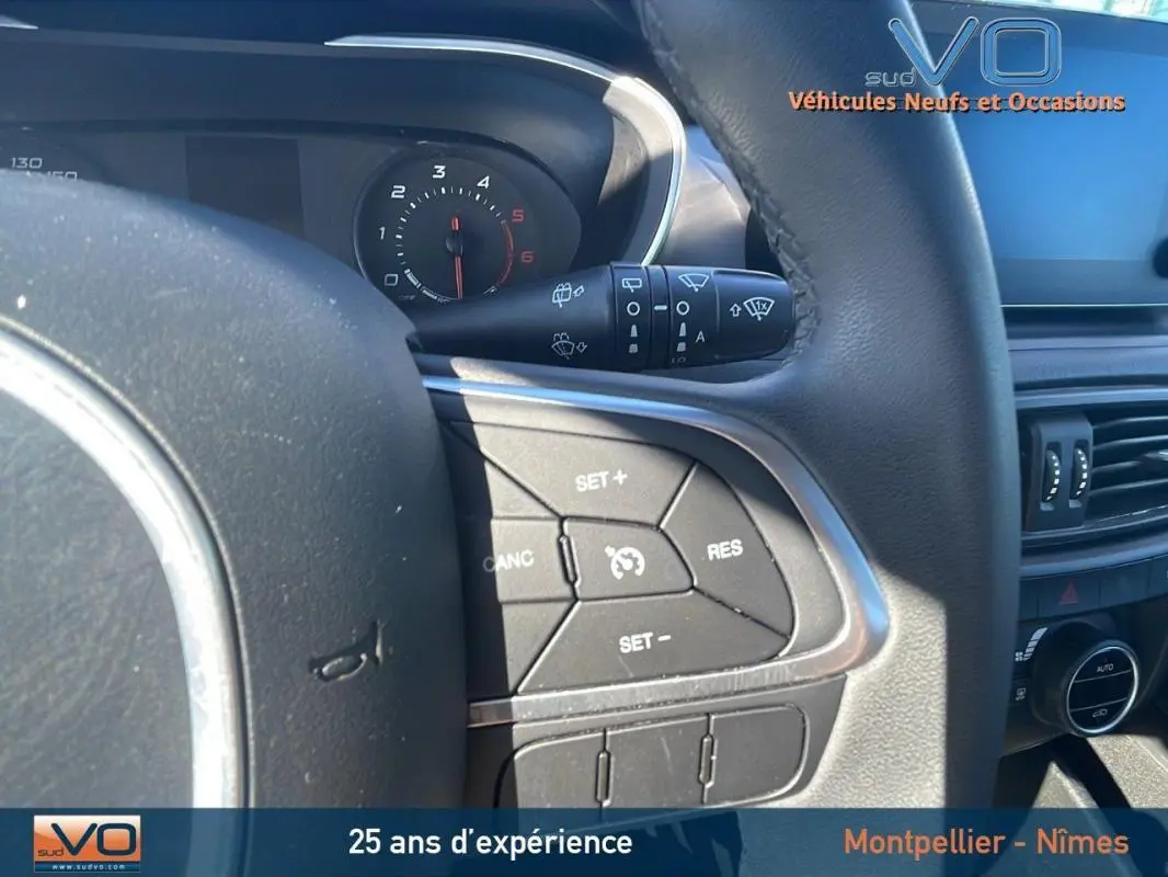 Gros plan sur le volant de la Fiat Tipo Station Wagon Business 2018, montrant les commandes de régulateur de vitesse.