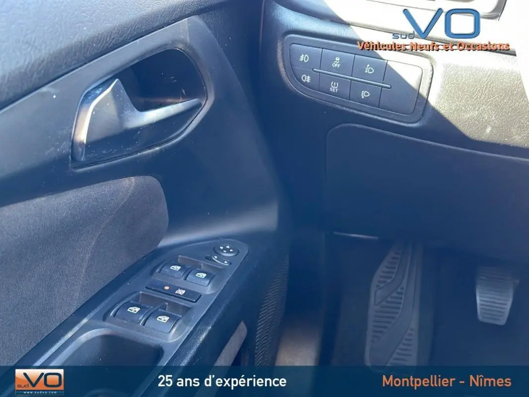 Détail des commandes de porte côté conducteur de la Fiat Tipo gris, avec boutons de vitres électriques et réglages des rétroviseurs.