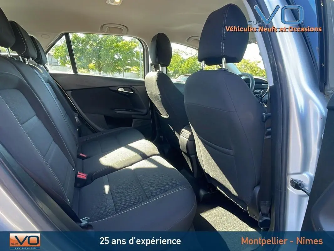 Vue intérieure arrière montrant les sièges noirs et les portes ouvertes côté droit d'un FIAT TIPO gris 2018 station wagon.