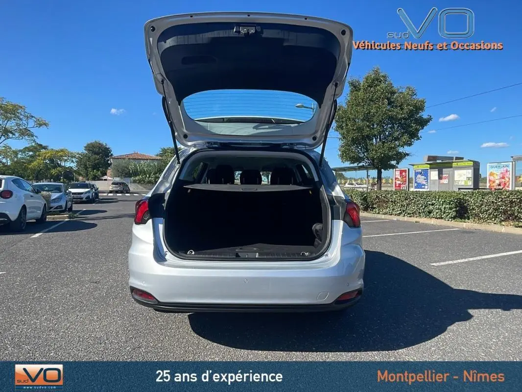 Vue arrière d'un FIAT TIPO gris 2018 avec coffre ouvert, station wagon en extérieur sur parking ensoleillé.