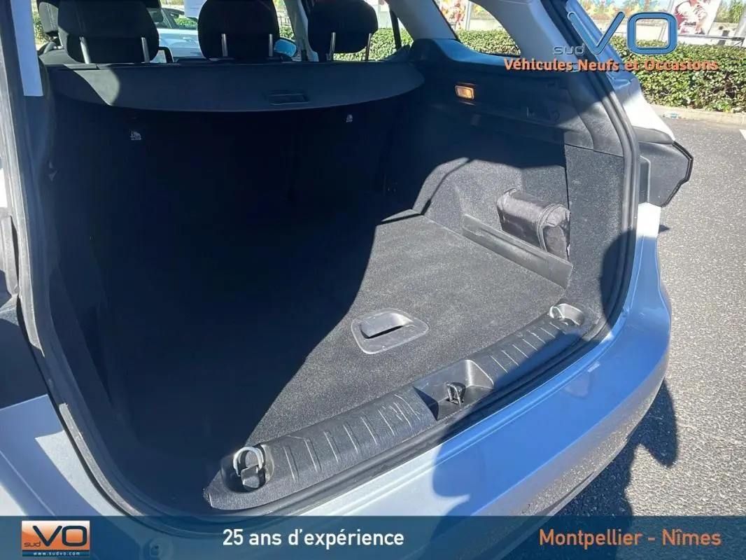 Coffre ouvert vu de l'arrière droit d'un FIAT TIPO gris avec barres de toit et jantes alliage 16 pouces.