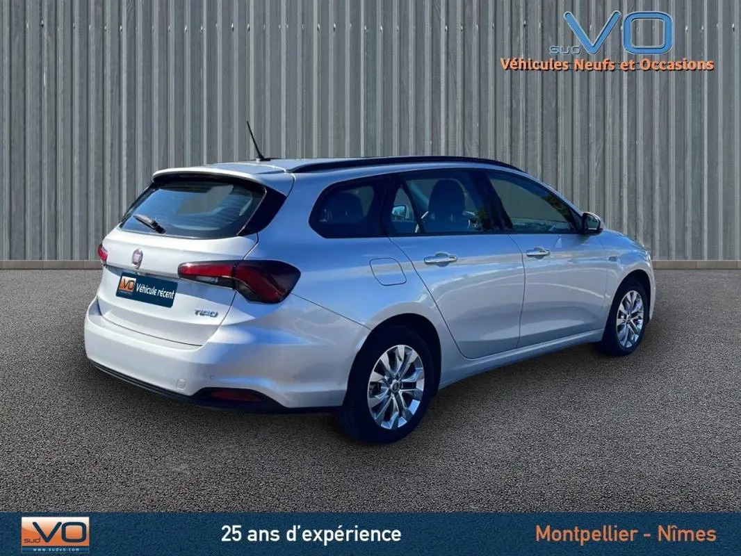 Fiat Tipo gris en station wagon vu en 3/4 arrière droit, avec jantes alliage et vitres teintées.